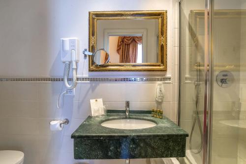 a bathroom with a sink and a shower at Hotel Machiavelli Palace in Florence