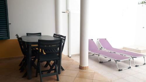 - une table et des chaises noires dans la chambre dans l'établissement A Casinha da Tita - Moradia com Terraço, à Zambujeira do Mar