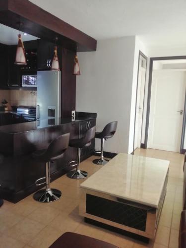 a kitchen with a bar with two chairs and a table at CommonLens Inn in Entebbe