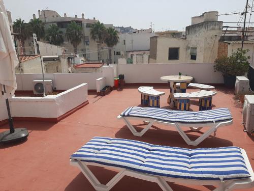 um pátio com duas mesas e cadeiras num telhado em Pension casa Fina Ruiz em Almuñécar