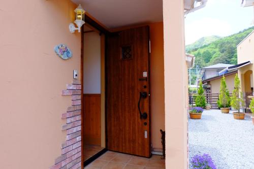a door to a house with a cat sitting next to it at Villa Ensoleille in Fujikawaguchiko