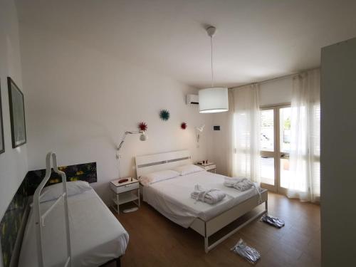- une chambre blanche avec un lit et une fenêtre dans l'établissement Il Giardino dei Pini, à Paestum