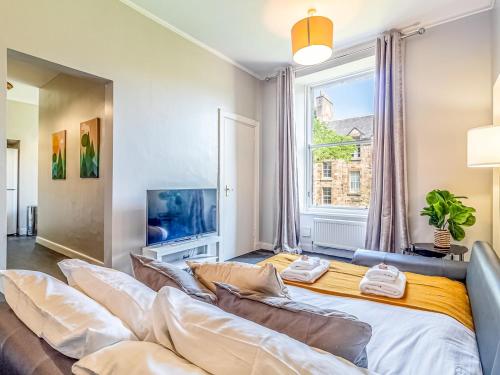 een woonkamer met een groot bed en een raam bij Pass the Keys Spacious and Homely flat on the Royal Mile in Edinburgh