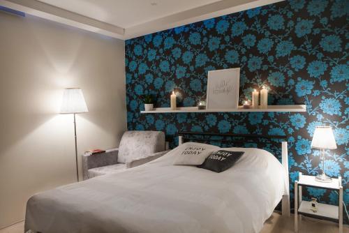 a bedroom with a bed and a chair with blue floral wallpaper at Hermann View Apartment in Tallinn