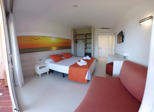pokój hotelowy z łóżkiem i kanapą w obiekcie Arenas de Son Bou w Son Bou