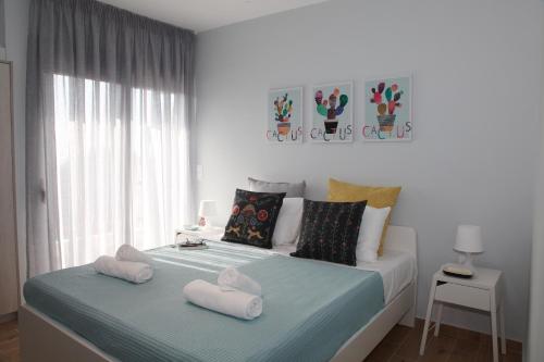 a bedroom with a bed with two towels on it at Edem Beach Apartment with Sea View by Athenian Homes in Athens