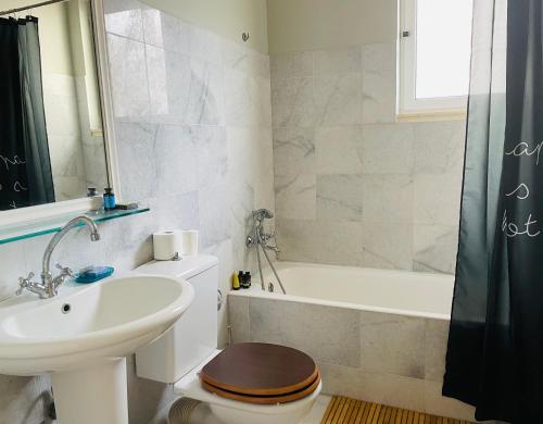 a bathroom with a sink and a toilet and a bath tub at Rex Hotel in Zakharo