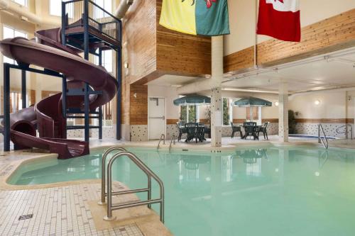 a swimming pool with a slide in a building at Days Inn by Wyndham Saskatoon in Saskatoon