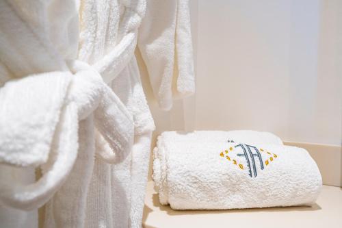 a pile of towels sitting on a table in a bathroom at Les Suites 7 Anges - Parking, Vue Cathédrale & Centre Historique Reims in Reims