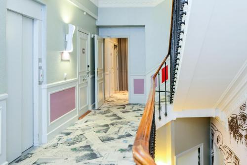 a hallway with a marble floor and a spiral staircase at Nice Excelsior Centre ville by HappyCulture in Nice