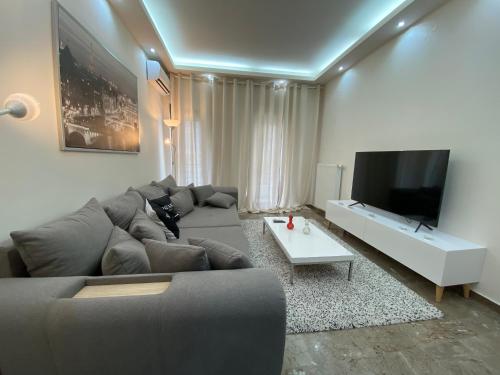 a living room with a couch and a flat screen tv at Ioannina Luxury Suites & Apartments in Ioannina