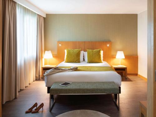 a hotel room with a bed and two lamps at Hotel Mercure Porto Gaia in Vila Nova de Gaia