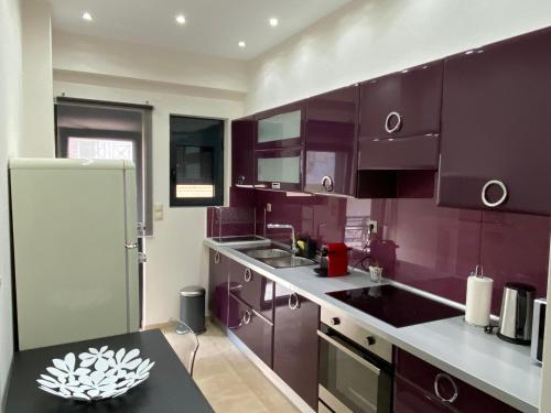 a kitchen with purple cabinets and a black counter top at Ioannina Luxury Suites & Apartments in Ioannina