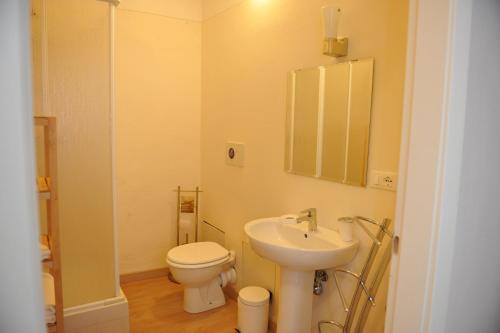 a bathroom with a sink and a toilet and a mirror at At Home Bed and Breakfast in Lucca