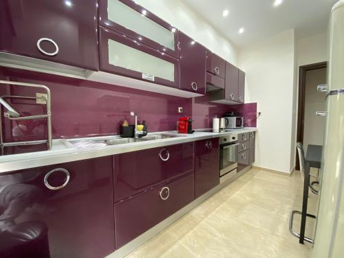 a kitchen with purple cabinets and stainless steel appliances at Ioannina Luxury Suites & Apartments in Ioannina