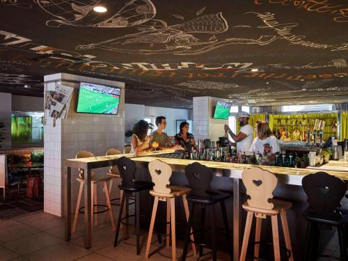 un bar en un restaurante con gente sentada en él en Mama Shelter Marseille, en Marsella