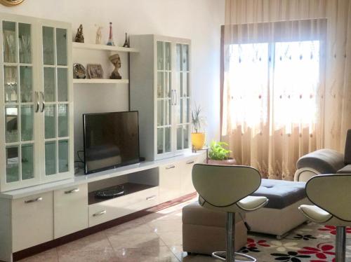 a living room with a entertainment center with a television at Fori Vodo in Divjakë