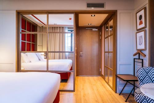 a hotel room with two beds and a hallway at Vincci Ponte de Ferro in Vila Nova de Gaia