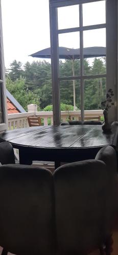 uma mesa num quarto com uma grande janela em Huize Koempoelan em Naarden