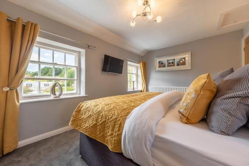 a bedroom with a bed and a window at White Rose Cottage in Constable Burton