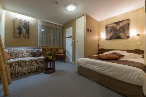 1 dormitorio con cama y sofá en Hôtel Auberge Du Morge, en Les Échelles