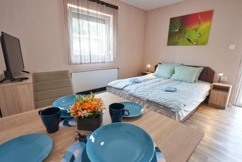 a bedroom with a bed and two tables and a tv at Thermal Apartman - FSZ in Gárdony