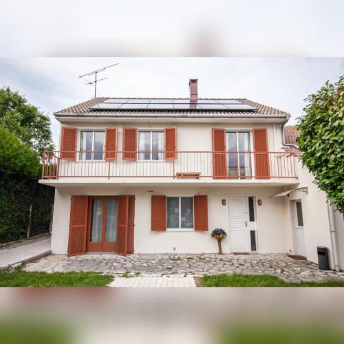 Cette grande maison blanche dispose d'un balcon. dans l'établissement Appartement 3pieces, à Pierrelaye