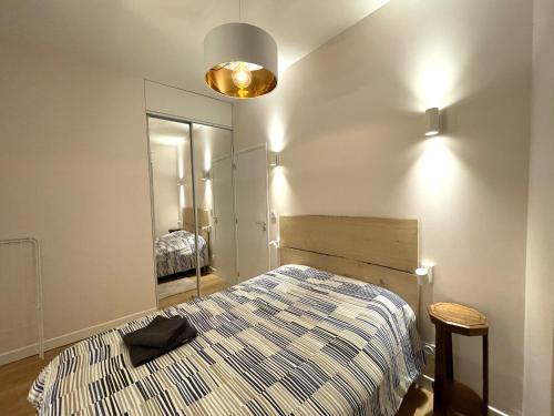 Schlafzimmer mit einem Bett und einem Spiegel in der Unterkunft Chez Emile - Sole' Île - T3 superbe - avec vue in Niort