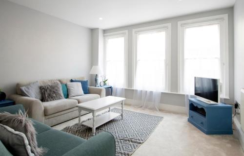 a living room with a couch and a tv at Modern apartment in Leamington Spa City Centre in Leamington Spa