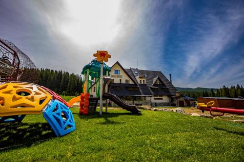 un parque infantil con un tobogán en el césped en Casa Iustin, en Moroeni