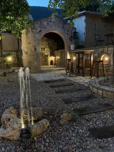 a garden with a fountain in the middle of a yard at Esperides Parga Studios in Parga