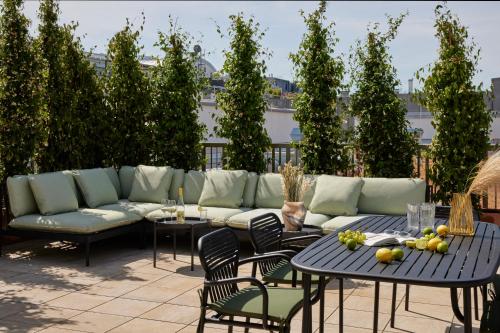 a patio with a couch and tables and chairs at Schwan Locke in Munich