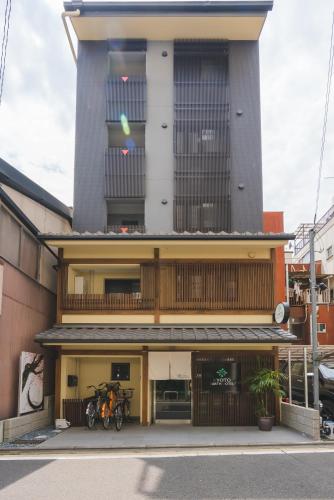 a building with two motorcycles parked in front of it at Kyoto Earth Hotel in Kyoto