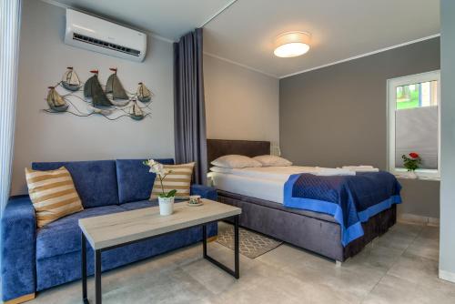 ミコワイキにあるEnklawa Mikołajkiのベッドルーム(ベッド1台、青いソファ付)