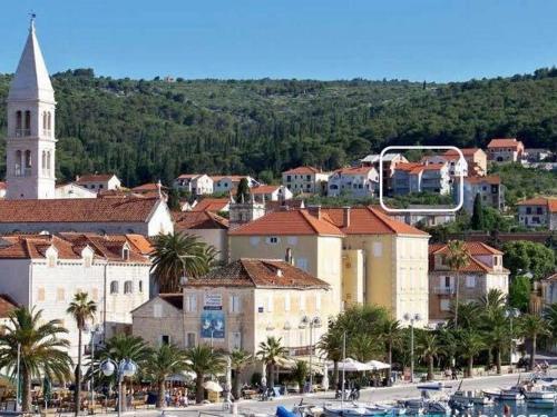 a city with a church and a town with boats at Apartment Lana ST in Supetar
