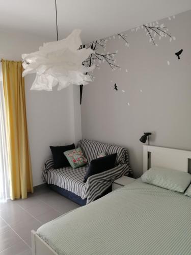 een woonkamer met een bank en een bed bij Elef Apartment in Paralia Dionysiou