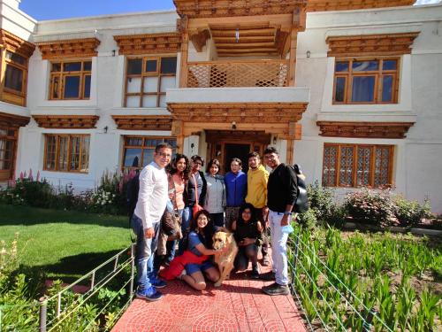 a group of people standing in front of a house at Namra Villa in Leh