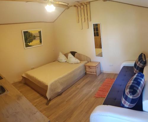 sypialnia z 2 łóżkami i kanapą w obiekcie namelis nr 2 Adelės sodyba w mieście Muižė