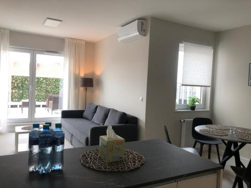 a living room with a couch and a table with water bottles at Apartament De Lux Apart 45 Grabiszyńska in Wrocław