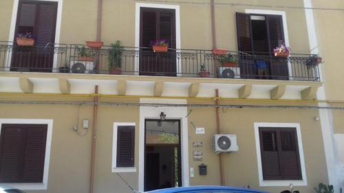 un edificio con due balconi e una porta con piante di Le Casette di Laura a Palermo