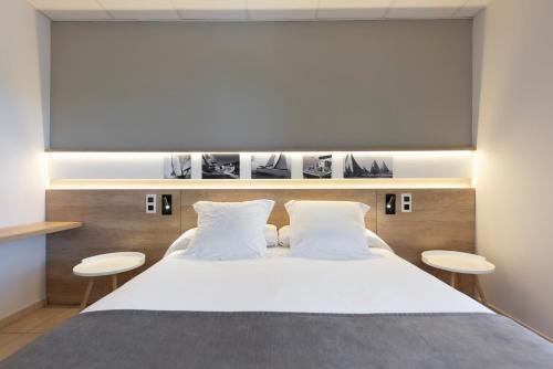 ein Schlafzimmer mit einem großen Bett mit zwei Hockern in der Unterkunft Apartaments Terraza - Santa Maria in Roses