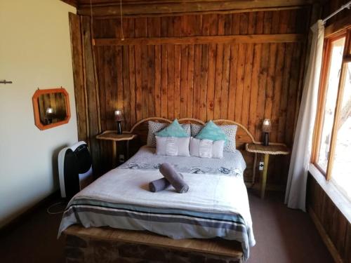 a bedroom with a bed with blue and white pillows at ThabaNkwe Bushveld Inn in Thabazimbi
