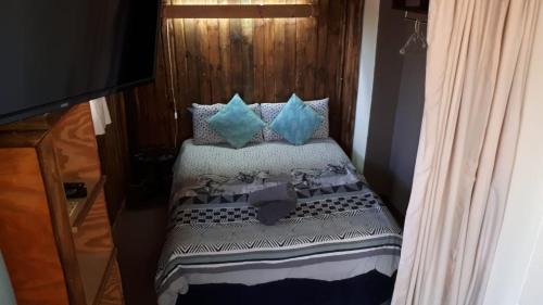 a bed with blue pillows on top of it at ThabaNkwe Bushveld Inn in Thabazimbi