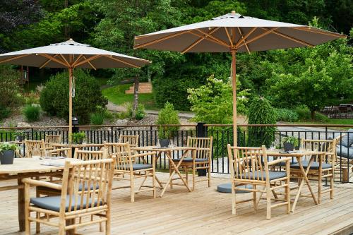 eine Terrasse mit Tischen, Stühlen und Sonnenschirmen in der Unterkunft FREIgeist Northeim in Northeim