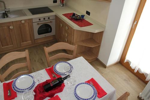 a kitchen with a table with plates and wine glasses at Appartamenti Dany in Arabba