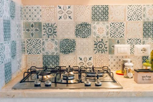 La cocina está equipada con fogones y azulejos. en Cafiero House Catania Downtown by Sicily in Home, en Catania