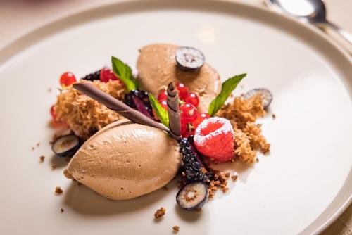 a white plate with a dessert on it at Landhotel Häuserl im Wald in Gröbming