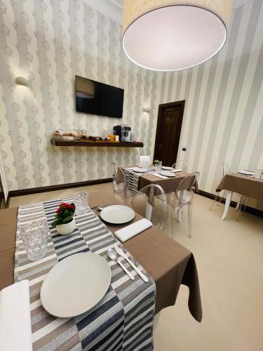 a dining room with tables and chairs and a chandelier at L’Arco Bed&Breakfast in Avigliano