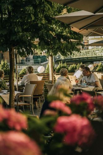 a group of people sitting at tables in a restaurant at Hotel Goldener Ochs in Bad Ischl