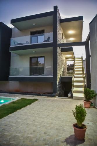 a house with a staircase and a swimming pool at Del Mar 'Adults Only' in Stalida